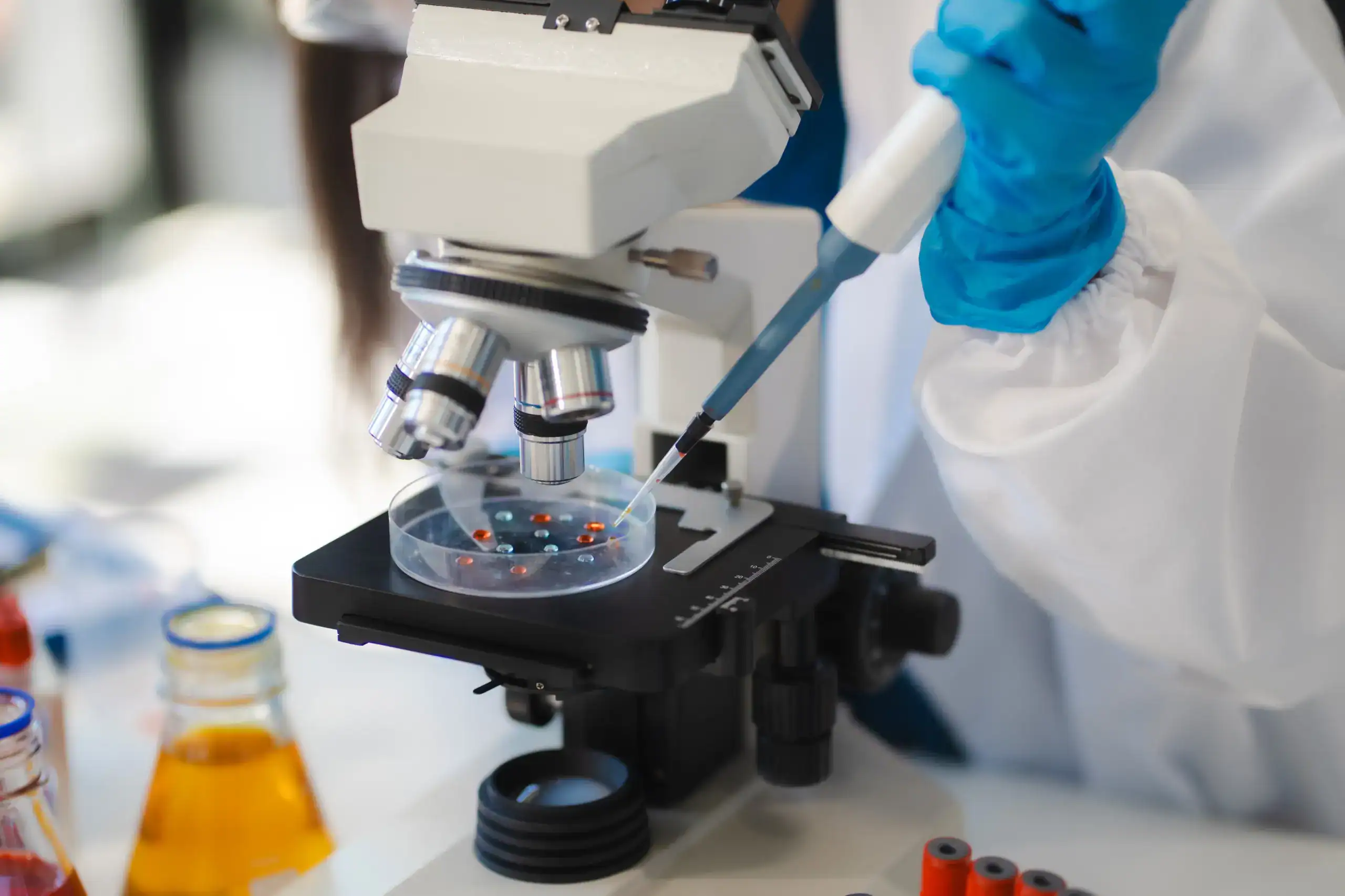 Laboratory researcher examining a sample under a microscope for stem cell therapy research